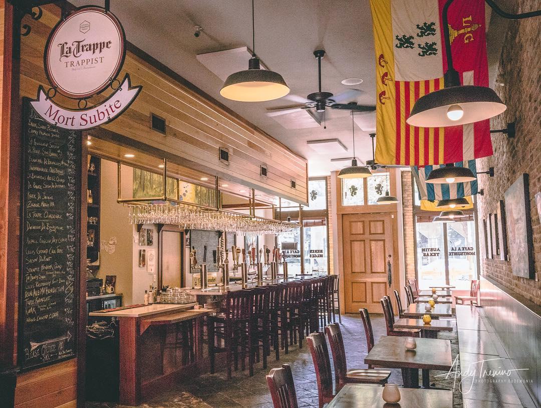 The bar at Mort Subite: white marble, hanging Belgian glassware, brewery plaques on the wall